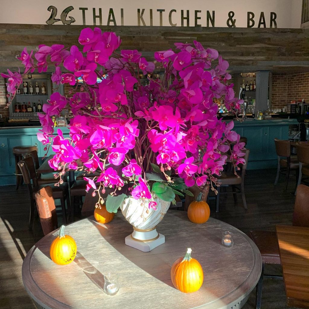 Earth toned restaurant with flower decorated tables at Twenty Six Thai Kitchen