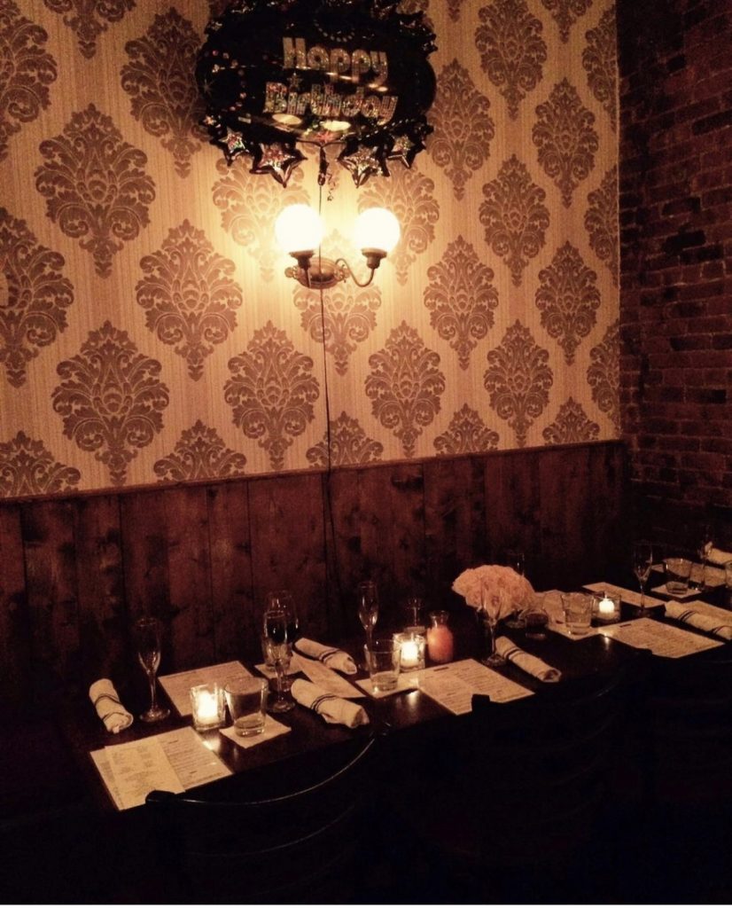 Formally arranged tables set against wallpaper covered walls at Babbalucci