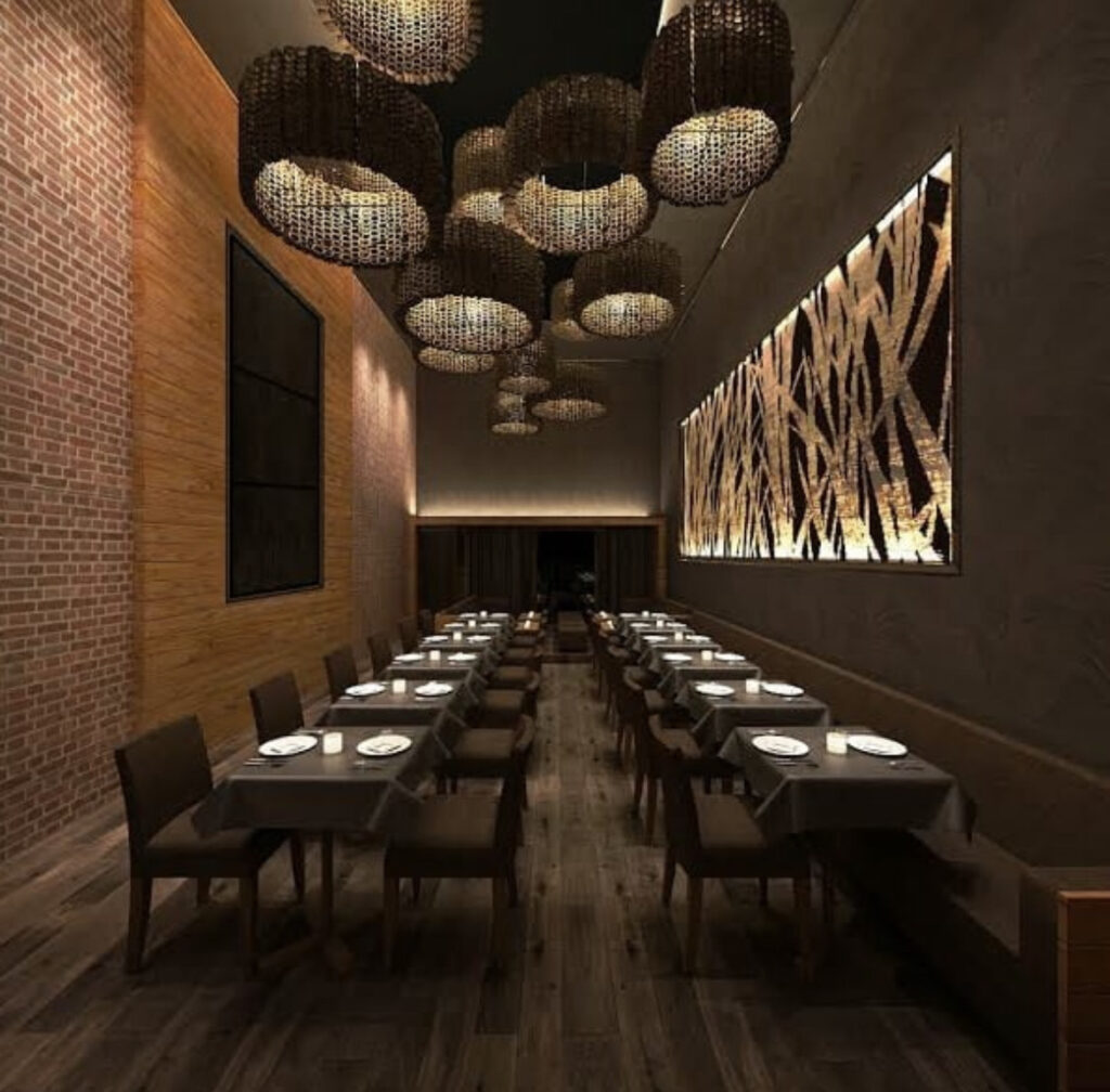 Interior of earth toned, elegant restaurant decorated with a painting and raffia lamp shades at Suede