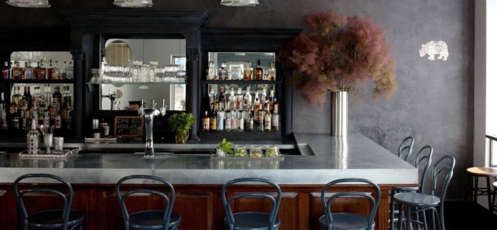 Bar with gray walls and gray stools at Vinateria